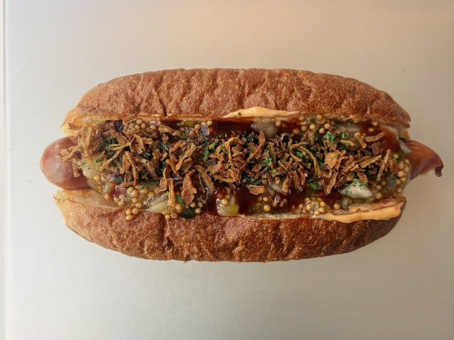 フライドオニオンと玉ねぎピクルスがたっぷりのったホットドッグ